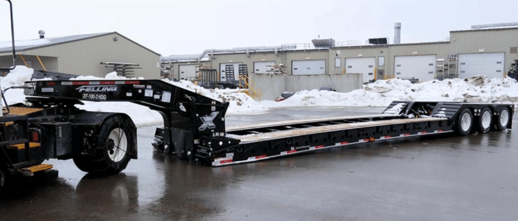lowboy trailer used for hauling different types of heavy equipments