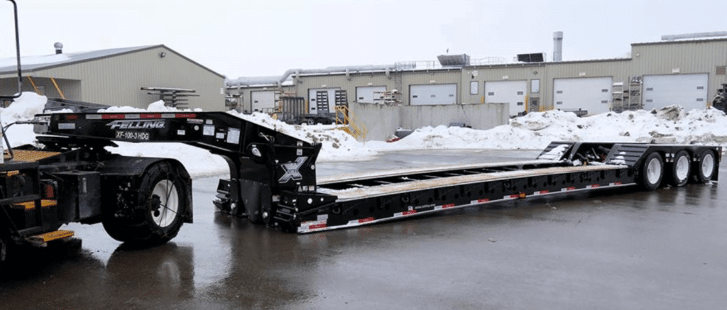 lowboy trailer used for hauling different types of heavy equipments